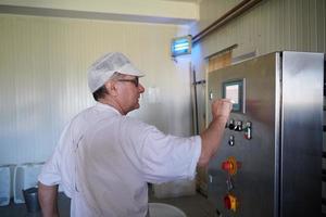 Cheese production cheesemaker  working in factory photo