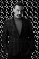 Black and white portrait of a stylish elegant senior businessman with a beard and casual business clothes against retro colorful pattern design background gesturing with hands photo