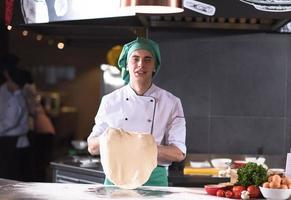 chef throwing up pizza dough photo