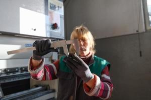 una mujer que trabaja en una fábrica moderna para la producción y procesamiento de metales, preparando y midiendo materiales que van al procesamiento de máquinas cnc foto