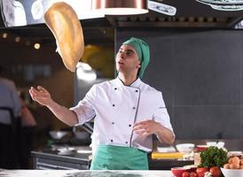 chef throwing up pizza dough photo