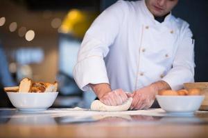 young chef preparing dough for pizza photo