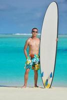 Man with surf board on beach photo