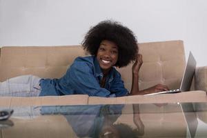 African American woman using laptop on sofa photo