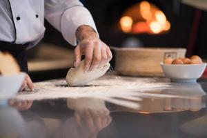 chef hands preparing dough for pizza photo