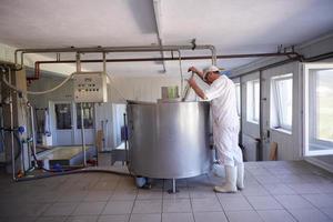 Cheese production cheesemaker  working in factory photo