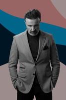 Black and white portrait of a stylish elegant senior businessman with a beard and casual business clothes against retro colorful pattern design background gesturing with hands photo