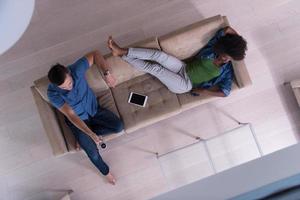 multiethnic couple relaxes in the living room top view photo