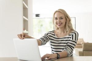 Young woman with laptop at home photo