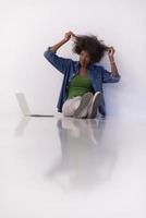 african american woman sitting on floor with laptop photo