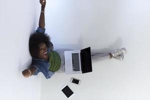 mujer afroamericana sentada en el suelo con vista superior del portátil foto