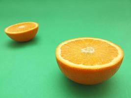 sliced orange macro on green background photo