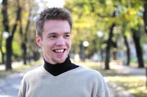 Handsome young man smiling outdoors photo