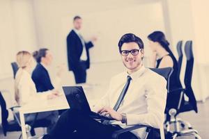 handsome young business man with colleagues in background photo