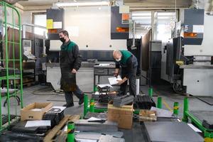 Turkey, 2022 - two workers wearing a protective mask due to a coronavirus pandemic, working in a modern factory and preparing a program and materials for a cnc machine photo