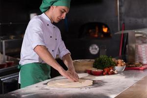 chef preparing dough for pizza photo