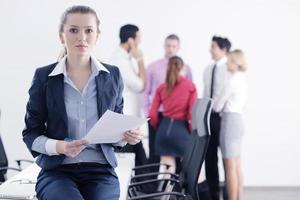 business woman standing with her staff in background photo