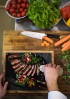 top view of Chef finishing steak meat plate photo