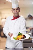 chef in hotel kitchen preparing and decorating food photo