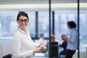 Elegant Woman Using Mobile Phone in startup office building photo