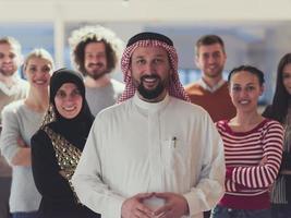 retrato de un grupo multirracial diverso de empresarios que se encuentran detrás de un líder de equipo árabe mayor foto