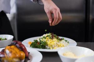 chef manos sirviendo risotto de verduras foto