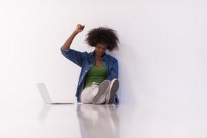 african american woman sitting on floor with laptop photo