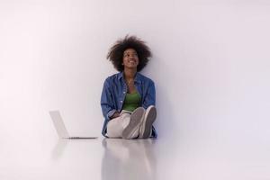 mujer afroamericana sentada en el suelo con una laptop foto