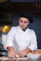 young chef preparing dough for pizza photo