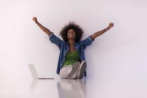 mujer afroamericana sentada en el suelo con una laptop foto