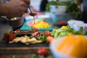 Chef hand finishing steak meat plate photo