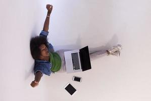 african american woman sitting on floor with laptop top view photo