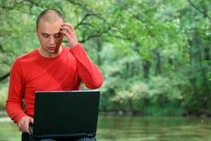 young businessman working on laptop outdoor photo