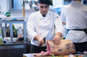 chef cutting big piece of beef photo