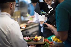 videographer recording while team cooks and chefs preparing meal photo