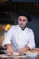 young chef preparing dough for pizza photo