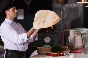 chef throwing up pizza dough photo