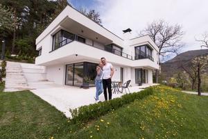 couple hugging in front of  new luxury home photo