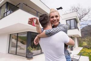 pareja abrazándose frente a una nueva casa de lujo foto