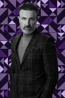 Black and white portrait of a stylish elegant senior businessman with a beard and casual business clothes against retro colorful pattern design background gesturing with hands photo