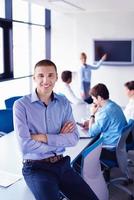 business man  on a meeting in offce with colleagues in background photo