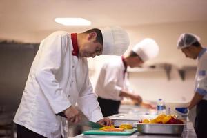 chef en la cocina del hotel preparando y decorando comida foto