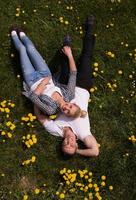 man and woman lying on the grass photo