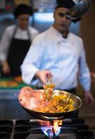 Chef doing flambe on food photo