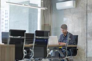 hombre de negocios que trabaja usando una computadora portátil en la oficina de inicio foto