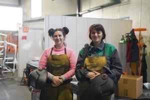 portrait of two welders holding welding masks in their hands and preparing for hard work in a factory photo