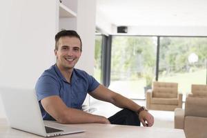 Young man with laptop at home photo