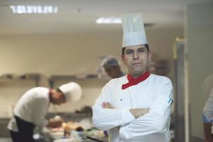 chef en la cocina del hotel preparando y decorando comida foto