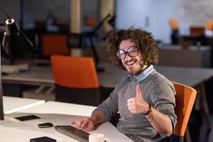 man working on computer in dark startup office photo