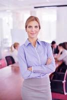 business woman with her staff in background at office photo